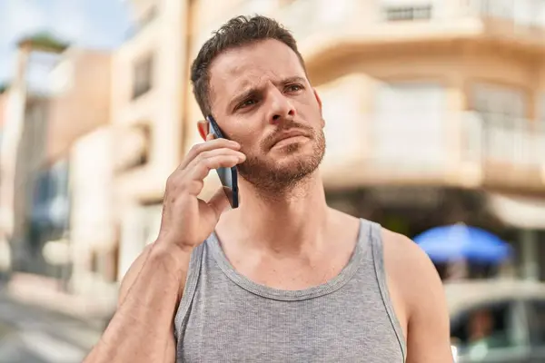 Jovem Hispânico Homem Falando Smartphone Com Expressão Séria Rua — Fotografia de Stock