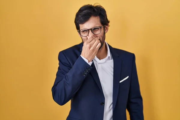 Handsome Latin Man Standing Yellow Background Smelling Something Stinky Disgusting — Fotografia de Stock