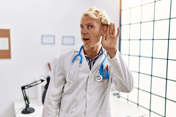 Young Blond Man Wearing Doctor Uniform Stethoscope Clinic Smiling Hand — Foto Stock