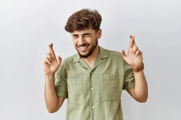Young Arab Doctor Man Standing Isolated Background Gesturing Finger Crossed — Stockfoto