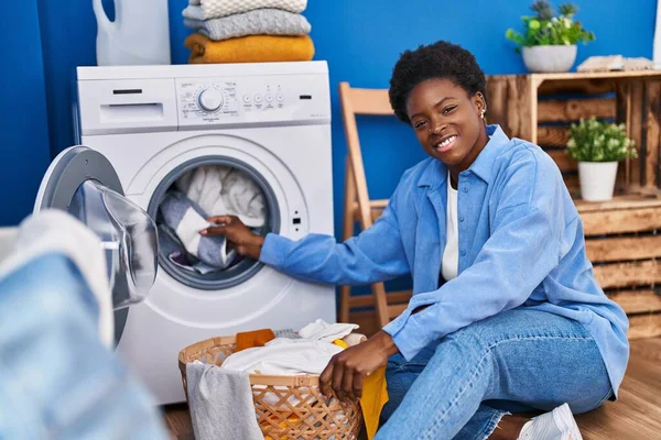 African American Woman Smiling Confident Using Washing Machine Laundry Room — стоковое фото