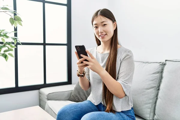 Jovem Mulher Asiática Usando Smartphone Sentado Sofá Sala Estar — Fotografia de Stock