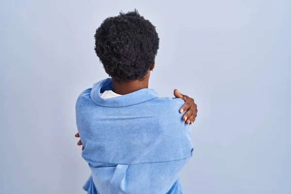 Αφροαμερικανή Που Στέκεται Πάνω Από Μπλε Φόντο Αγκαλιάζοντας Τον Εαυτό — Φωτογραφία Αρχείου