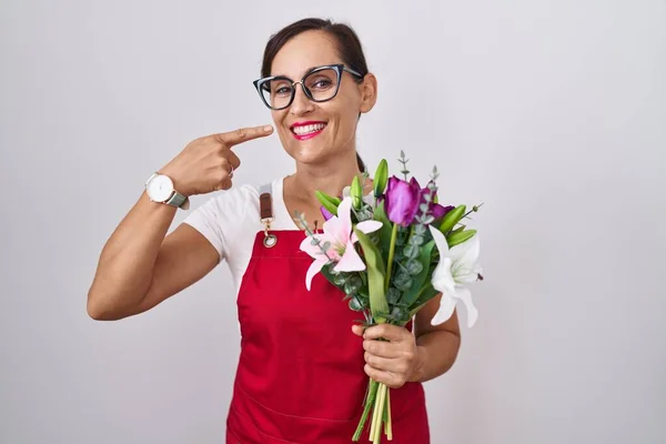 Çiçekçide Çalışan Esmer Önlük Giyen Elinde Buketle Gülümseyen Parmaklarıyla Ağzıyla — Stok fotoğraf