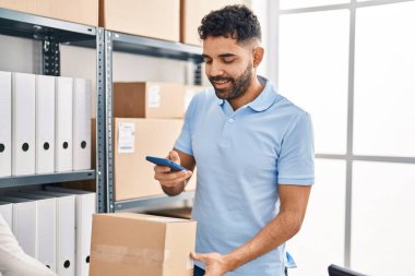 Young hispanic man ecommerce business worker make photo to package at office