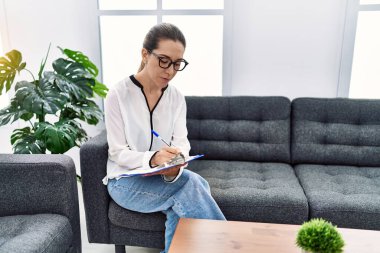 Young hispanic woman working at psychology clinic