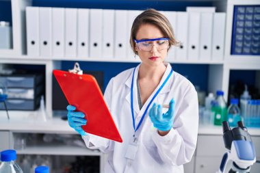 Genç bilim kadını laboratuarda örnek tutuyor.