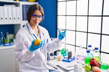 Limon ve hapları laboratuvarda tutan genç ve güzel İspanyol bilim kadını.