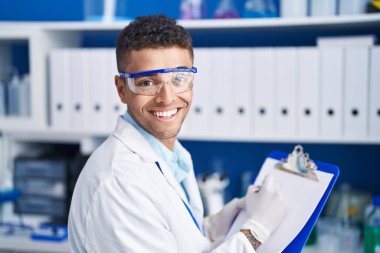 Afrikalı Amerikalı bilim adamı, laboratuardaki belgelere yazı yazıyor.