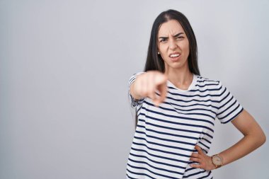 Çizgili tişört giyen genç esmer kadın kameraya kızgın ve sinirli bir şekilde seni işaret ediyor. 