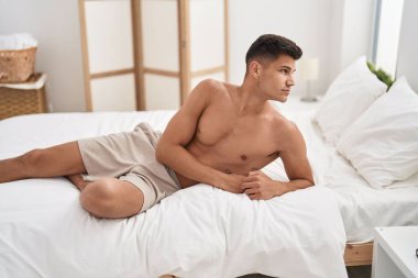 Genç İspanyol adam yatak odasında rahat bir ifadeyle yatakta yatıyor.