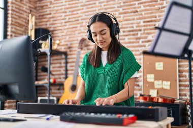 Genç İspanyol kadın müzisyen müzik stüdyosunda piyano çalıyor.