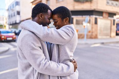 Man and woman couple hugging each other standing at street