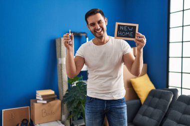 Sakallı, elinde yeni evin anahtarları olan genç bir İspanyol adam kahkahalarla gülüyor.. 