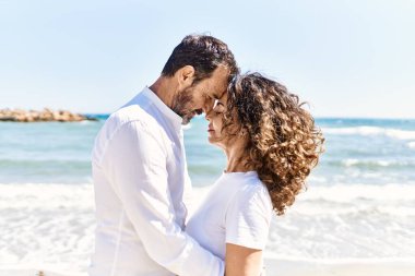 Orta yaşlı İspanyol çift sahilde sarılıyor..