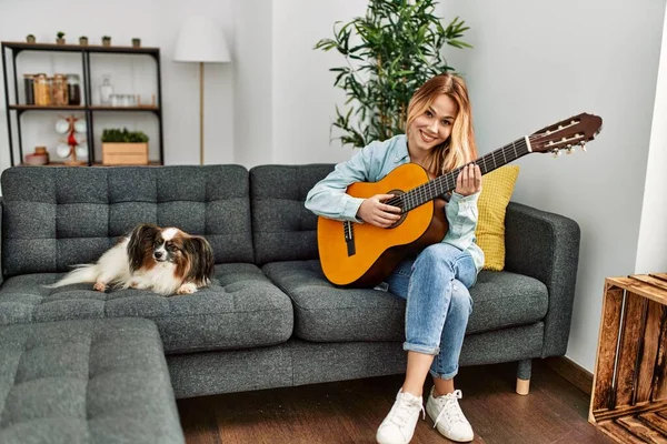 Jovem Caucasiana Tocando Guitarra Clássica Sentada Sofá Com Cão Casa — Fotografia de Stock