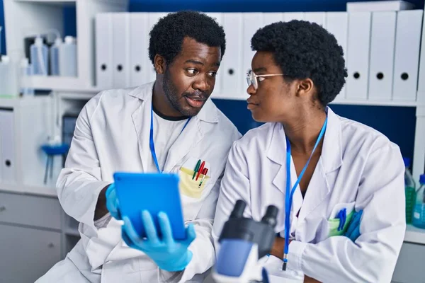アフリカ系アメリカ人の男性と女性科学者が実験室でタッチパッドを使って — ストック写真