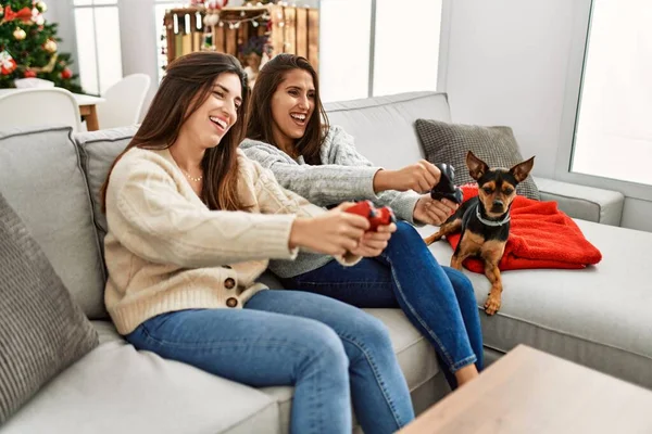 Duas Mulheres Jogando Videogame Sentado Com Cão Pela Árvore Natal — Fotografia de Stock