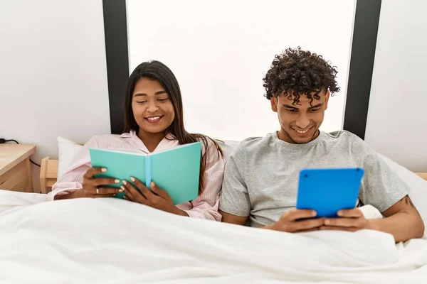 Jong Latijn Paar Lezen Boek Met Behulp Van Touchpad Zitten — Stockfoto