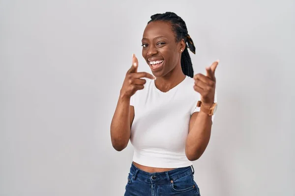 Beautiful black woman standing over isolated background pointing fingers to camera with happy and funny face. good energy and vibes.