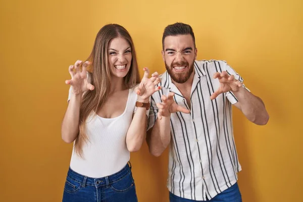 Young Couple Standing Yellow Background Smiling Funny Doing Claw Gesture — Stock Photo, Image