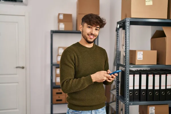 Young arab man ecommerce business worker using smartphone at office