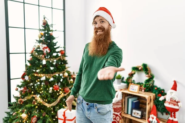 Κοκκινομάλλης Μακριά Γενειάδα Φορώντας Χριστουγεννιάτικο Καπέλο Από Χριστουγεννιάτικο Δέντρο Χαμογελώντας — Φωτογραφία Αρχείου