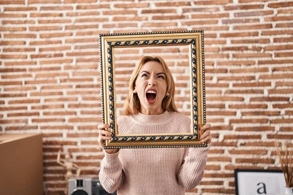 Hispanic Woman Holding Empty Frame Angry Mad Screaming Frustrated Furious — Stock Photo, Image