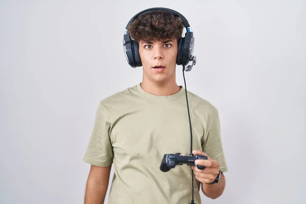 Hispanic Teenager Playing Video Game Holding Controller Shock Face Looking — Stock Photo, Image