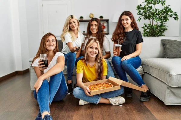 Group of young friends woman watching movie and eating italian pizza at home.