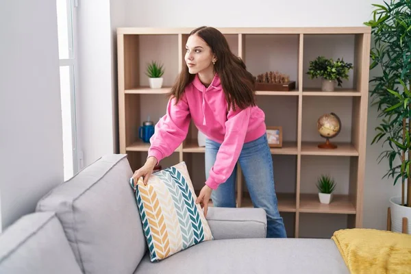 Mujer Joven Organizando Sofá Pie Casa —  Fotos de Stock