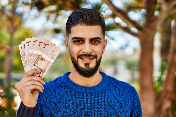 Jovem Árabe Sorrindo Confiante Segurando Notas Riyal Parque — Fotografia de Stock