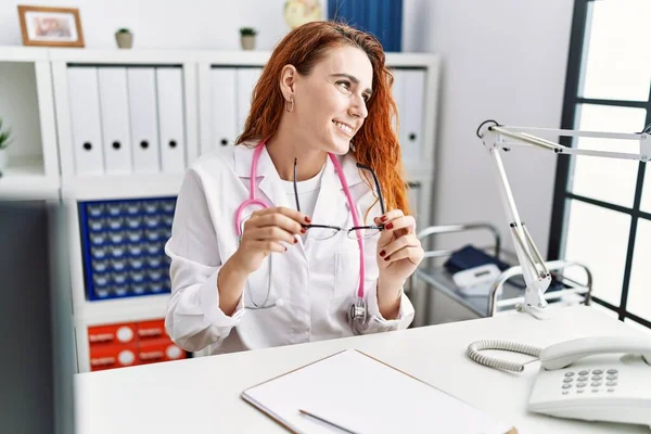Ung Rödhårig Kvinna Bär Läkare Uniform Hålla Glasögon Sjukhuset — Stockfoto