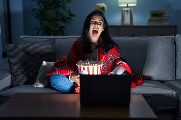 Hispanic Woman Eating Popcorn Watching Movie Sofa Sticking Tongue Out — Stock Photo, Image
