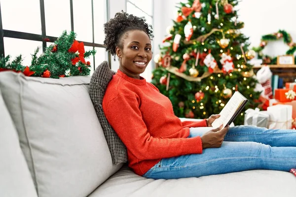 Αφροαμερικανή Γυναίκα Διαβάζει Βιβλίο Κάθεται Στον Καναπέ Από Χριστουγεννιάτικο Δέντρο — Φωτογραφία Αρχείου