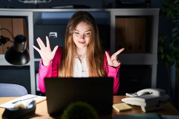 年轻的高加索女人晚上在办公室工作时 用七号手指显示和指点着 面带微笑 自信而快乐 — 图库照片