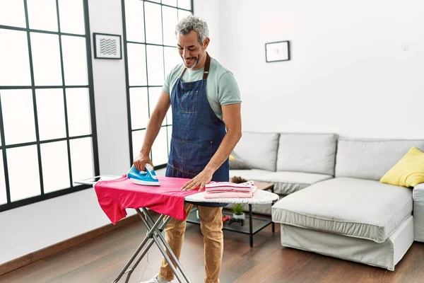 Hombre Pelo Gris Mediana Edad Sonriendo Ropa Planchar Segura Casa —  Fotos de Stock