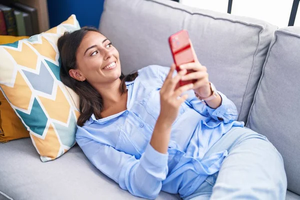 Jonge Mooie Spaanse Vrouw Met Behulp Van Smartphone Liggend Bank — Stockfoto