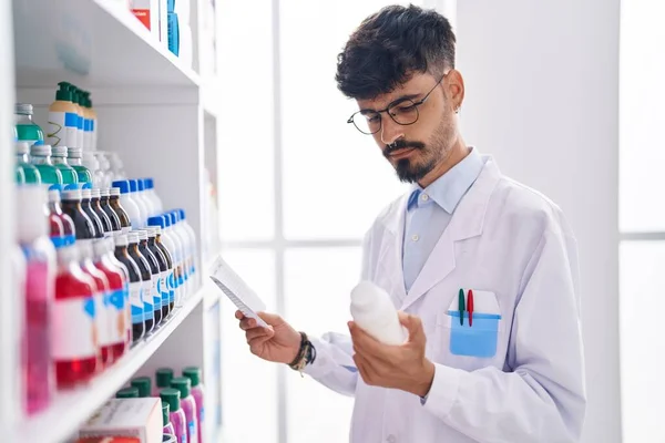 Young Hispanic Man Pharmacist Holding Pills Bottle Reading Preascription Pharmacy — Stock Photo, Image