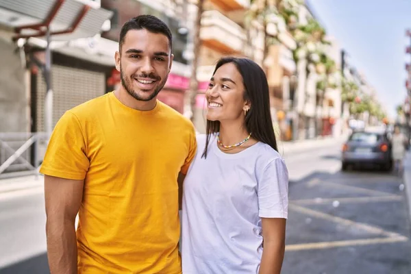 年轻的拉丁夫妇站在城中 开心地微笑着 拥抱着 — 图库照片