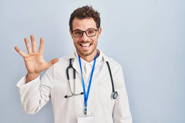 医師の制服と聴診器を身に着けている若いヒスパニック系の男が表示され 指番号5で指摘しながら 自信と幸せ笑顔 — ストック写真