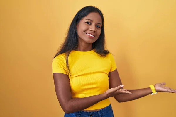 Ung Indian Kvinna Står Över Gul Bakgrund Inbjudande Att Komma — Stockfoto