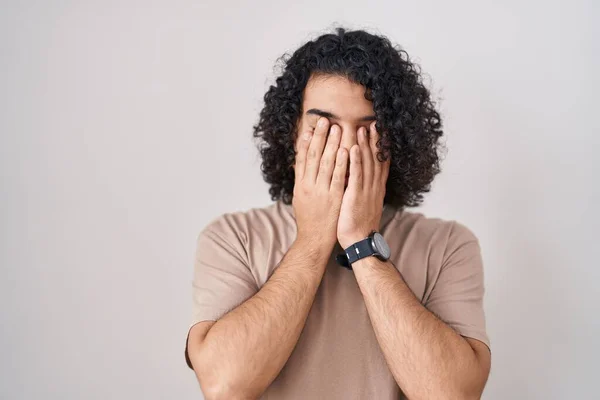 西班牙男人 卷曲的头发 站在白色的背景 揉揉眼睛 以消除疲劳和头痛 困倦和疲倦的表情 视力问题 — 图库照片
