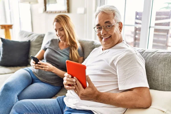 Middle Age Hispanic Couple Smiling Happy Using Tablet Smartphone Home — Φωτογραφία Αρχείου