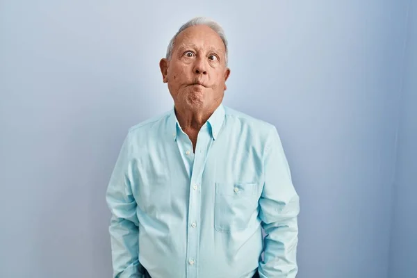 Mavi Arka Planda Gri Saçlı Yaşlı Adam Dudaklarıyla Balık Suratı — Stok fotoğraf