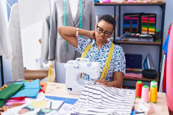 African american woman tailor stressed using sewing machine at tailor shop