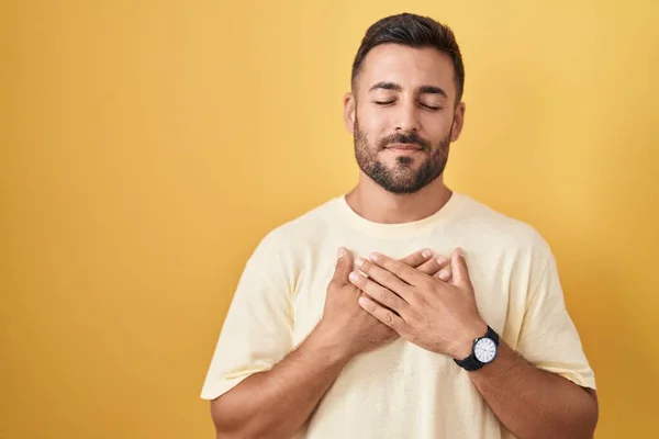 Bell Uomo Ispanico Piedi Sfondo Giallo Sorridente Con Mani Sul — Foto Stock