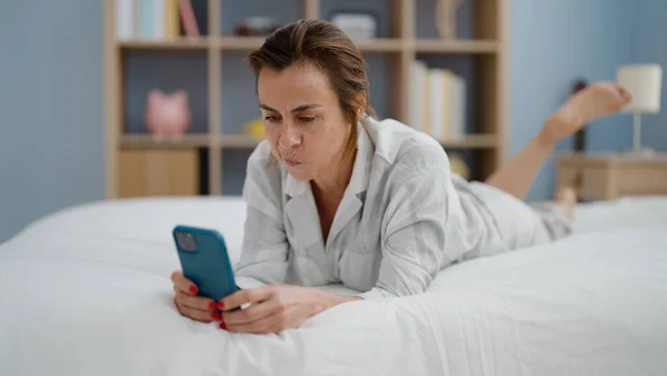 Latynoska Kobieta Średnim Wieku Pomocą Smartfona Leżącego Łóżku Sypialni — Zdjęcie stockowe