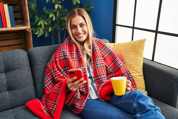 Ung Blond Kvinna Dricker Kaffe Och Använder Smartphone Hemma — Stockfoto