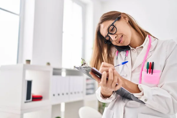Mujer Joven Vistiendo Uniforme Médico Hablando Teléfono Inteligente Escribir Portapapeles —  Fotos de Stock